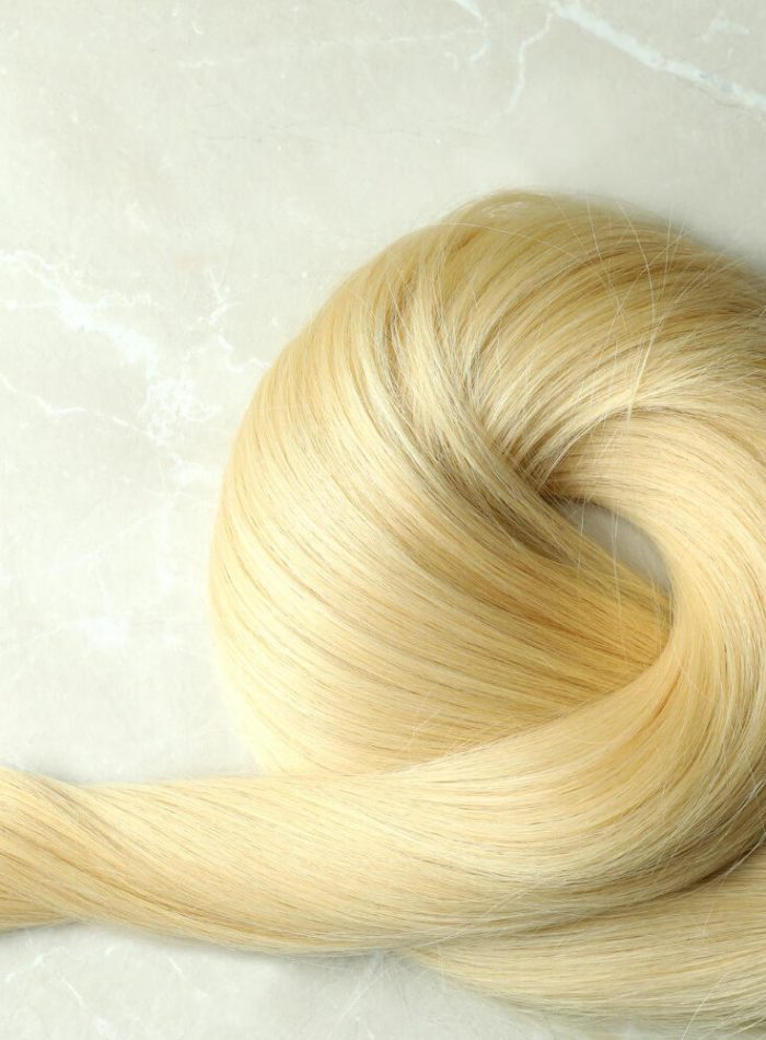 lock-blond-female-hair-light-background